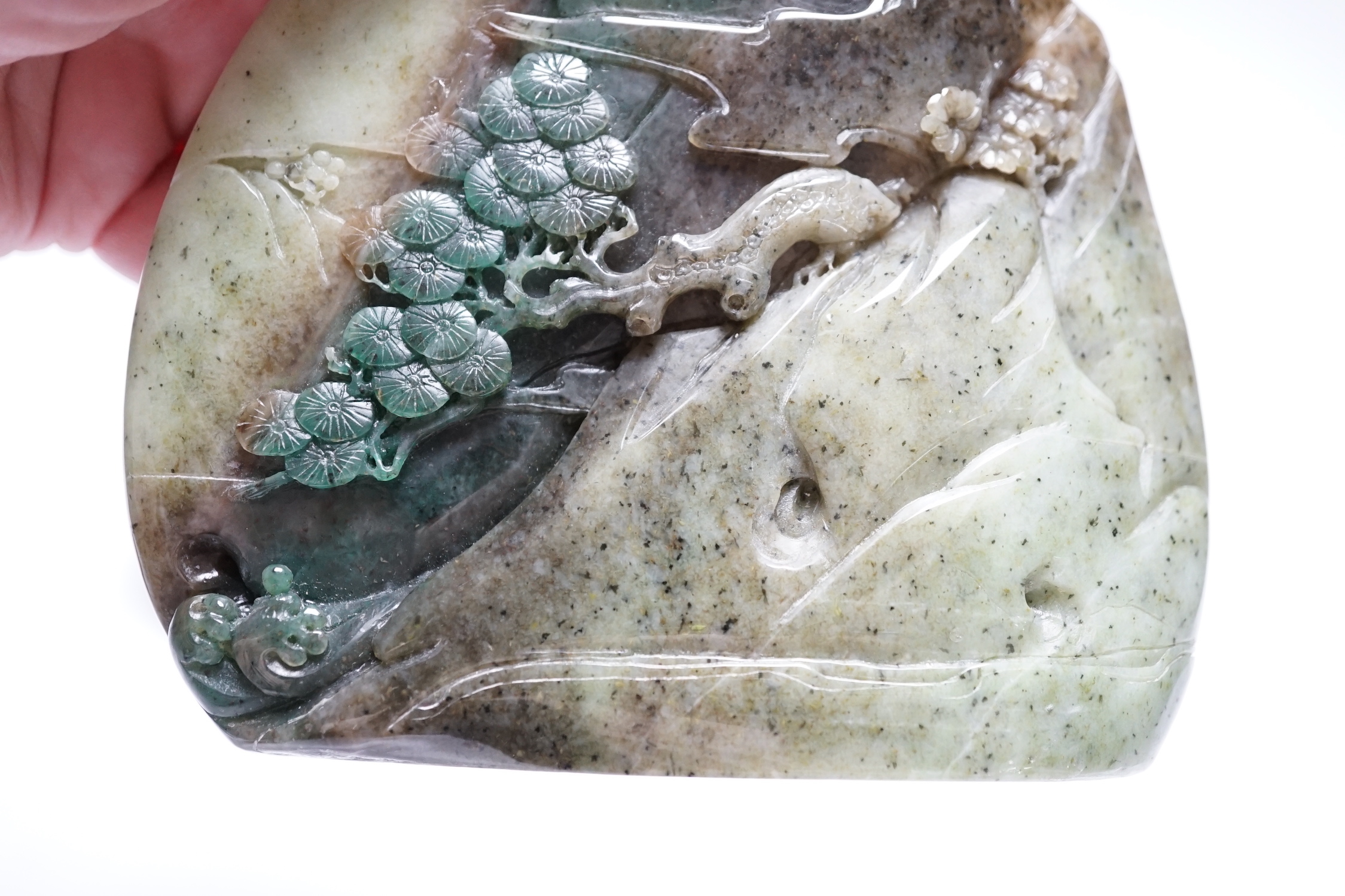 A Chinese jadeite boulder carving on hardwood stand, 17cm high